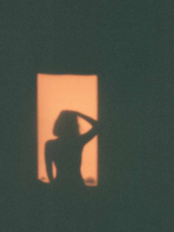 35mm film photograph of a window framing a rock formation over the sea